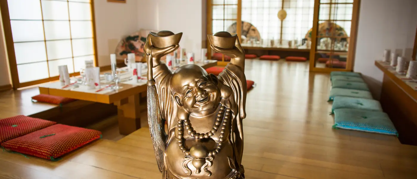 Salon décoré dans un style colonial asiatique avec mobilier ancien et paravent laqué