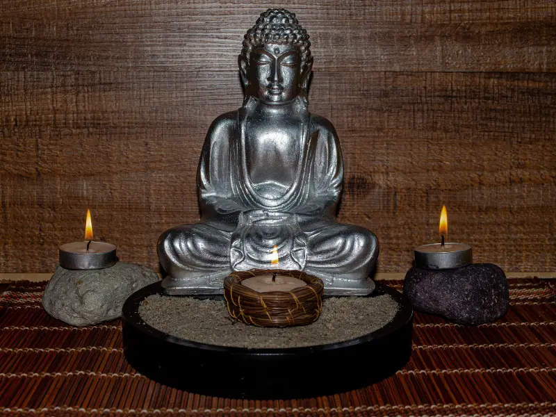 Statue bouddhique ancienne posée sur un autel en bois, encens et objets rituels