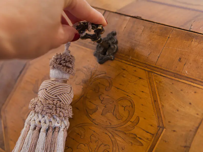 Main posée sur un meuble ancien, transmission d’un savoir-faire et d’une histoire